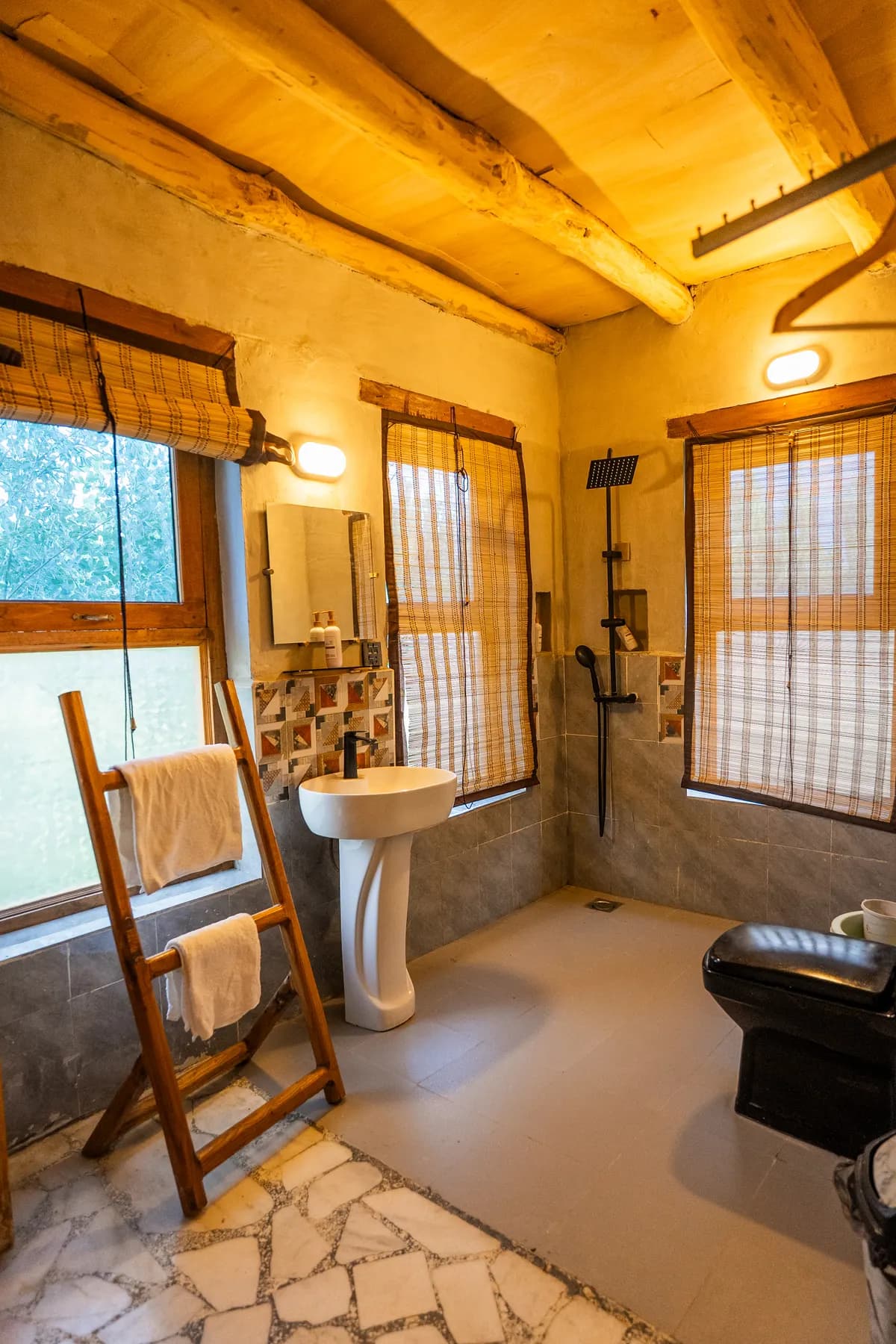 A stone-floor bathroom with bamboo blinds