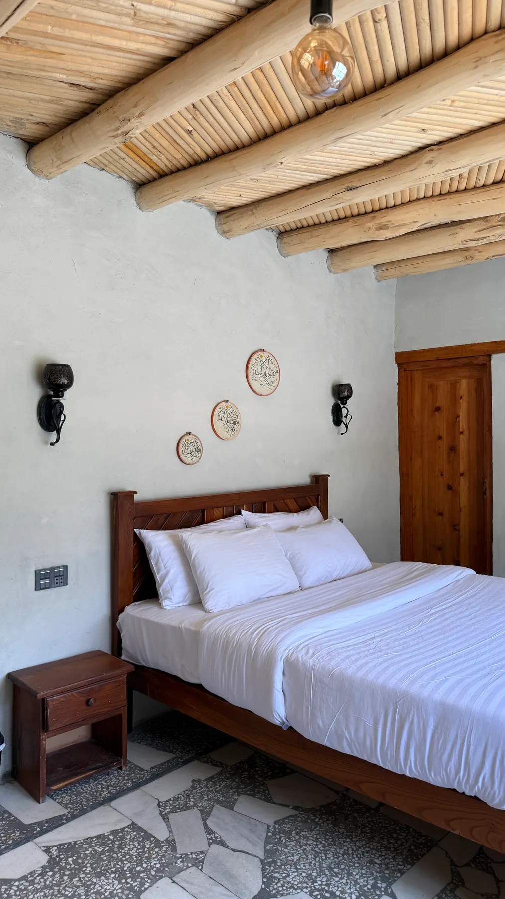 Embroidered hoops above a guest bed