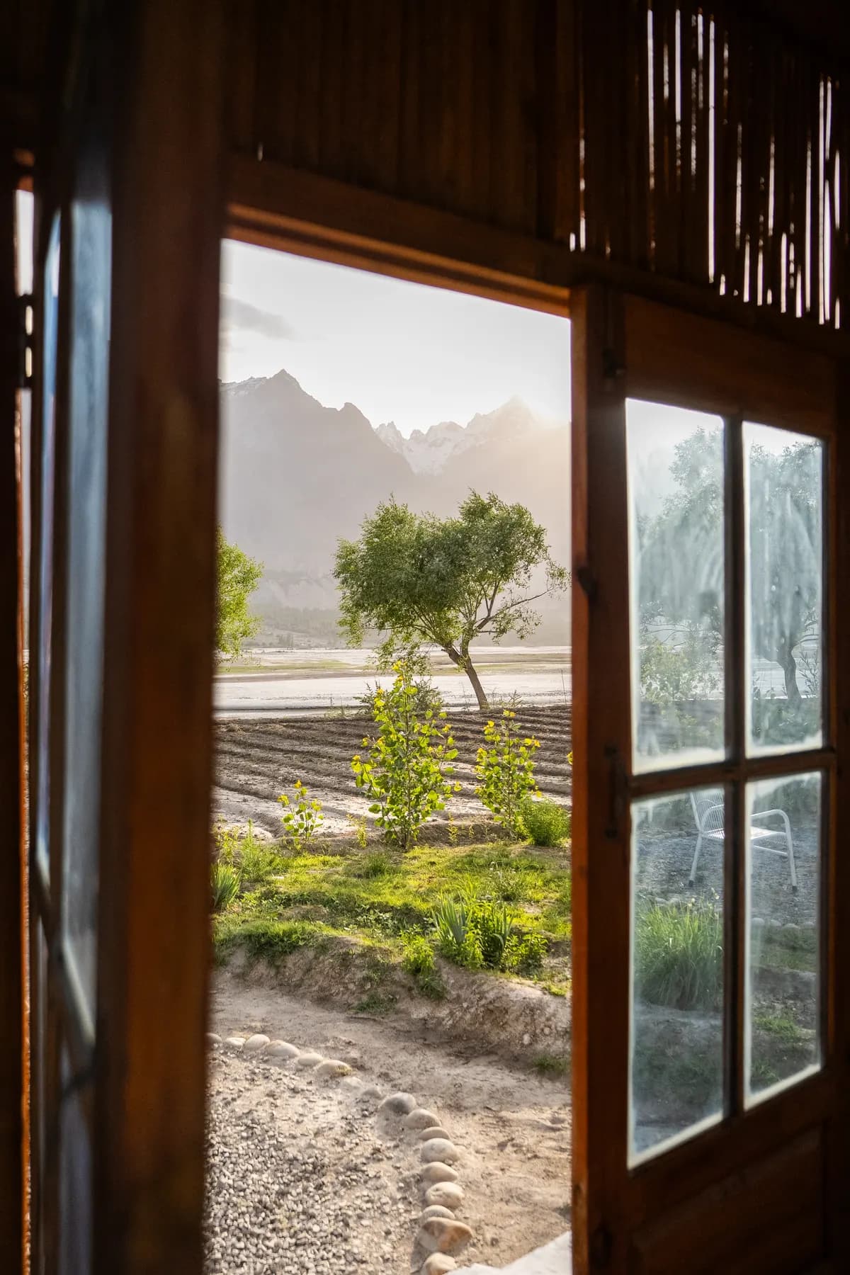 Snow peaks seen through an open lodge door