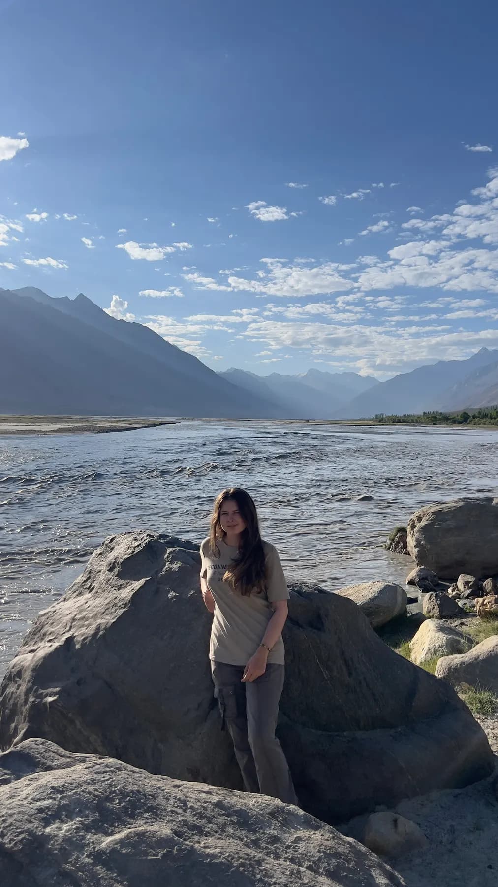 A guest standing on a river boulder in the valley