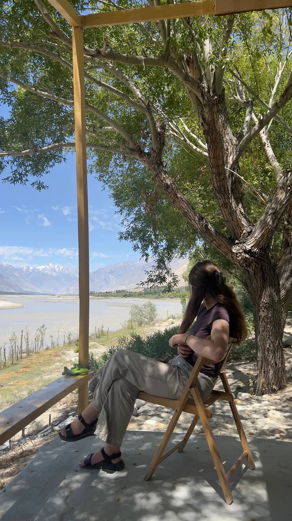 A guest sitting on the hut deck above the river