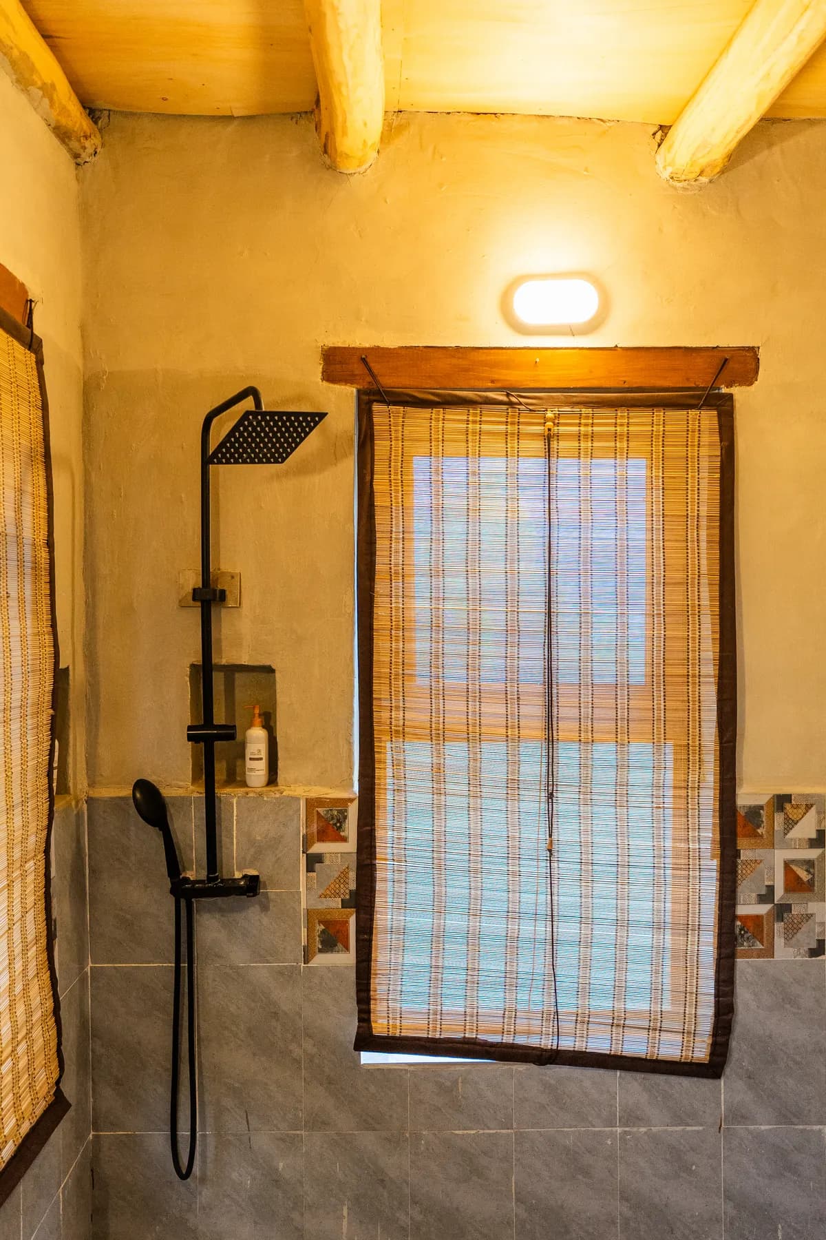 A black rain shower beside a bamboo shade