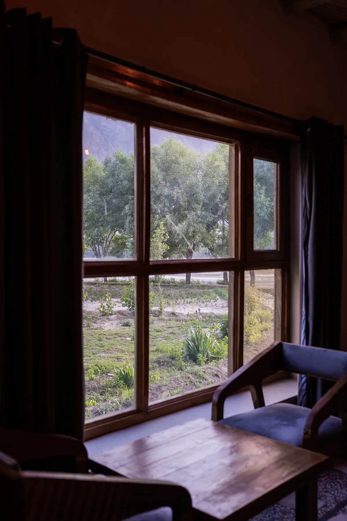 A quiet chair and the garden through a four-pane window