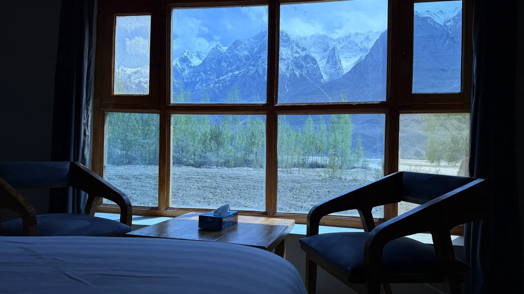 Snow mountains framed by a bedroom window