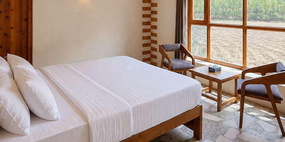 Deluxe room bed facing the orchard window